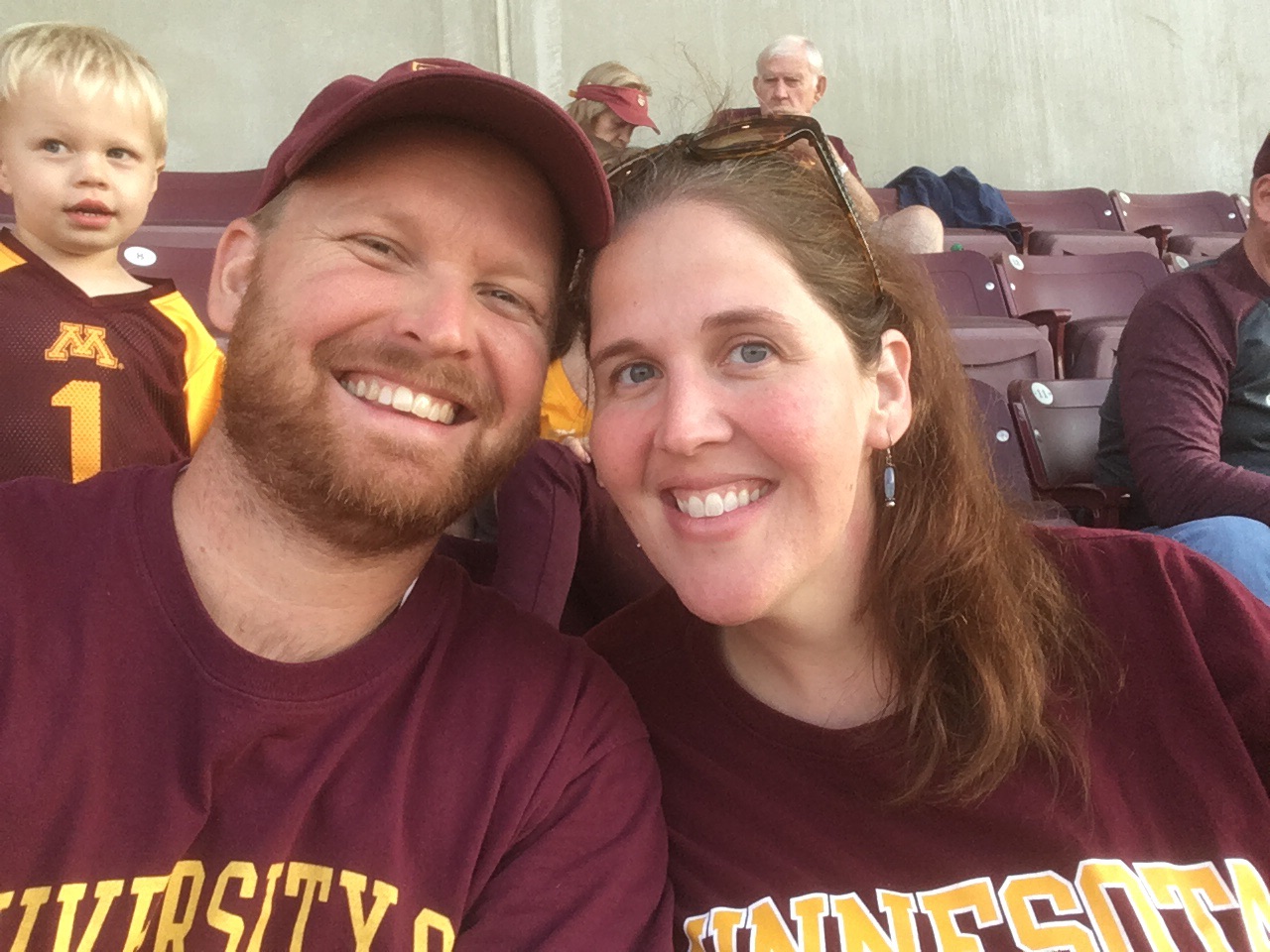 Pictured, Noelle Noonan, vice chair, P&A Consultative Committee and her husband _______. Senate Associate Chris Kwapick's son, Henry, pictured behind Noelle and John takes in the football scene.
