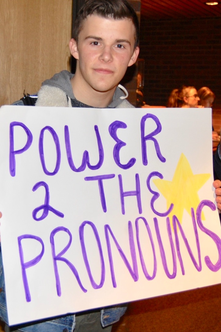 A student holds a sign reading \