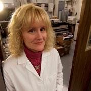 Elizabeth Ambrose, photographed wearing a lab coat outside of a lab
