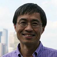 Jiali Gao headshot. He is wearing a purple checked button down shirt and glasses, and blurred behind him is the Minneapolis skyline.